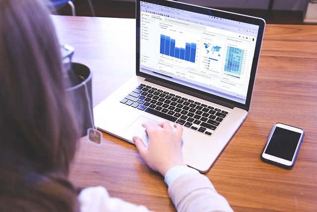 A woman using a laptop to access a digital marketing dashboard.